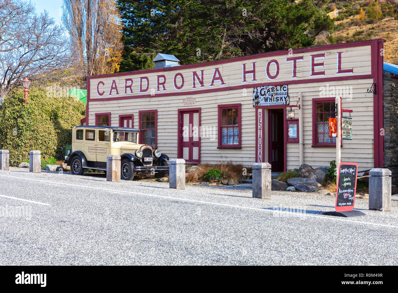 Cardrona Valley Road,  Cardrona, South Island, New Zealand - May 10, 2013:  Famous historic Cardrona Hotel and vintage car. Stock Photo