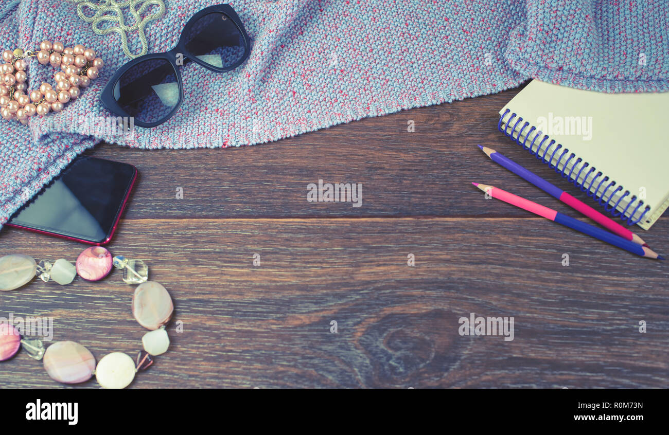 Banner Set of women's accessories mobile jewelry glasses notebook colored pencils. Wooden dark background top view flat lay copy space Stock Photo