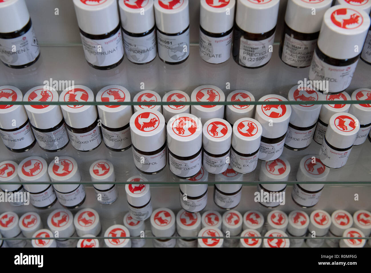 Holzminden, Germany. 23rd Oct, 2018. Fragrance raw materials in bottles with the Symrise AG logo are on a shelf. Symrise AG is one of the world's leading suppliers of fragrances and flavors. Credit: Swen Pförtner/dpa/Alamy Live News Stock Photo