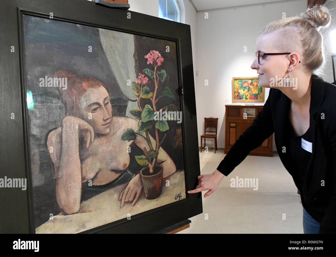 Schleswig, Germany. 06th Nov, 2018. Melanie Jacobi, provenance researcher at the Museum of Art and Cultural History, stands next to the painting 'Girl with Geranium' by Karl Hofer (1878-1955). For more than five years, the Schleswig-Holstein State Museums Foundation has been systematically examining and processing the collections of the Museum of Art and Cultural History. It is supported by the German Centre for the Loss of Cultural Assets in Magdeburg. Credit: Carsten Rehder/dpa/Alamy Live News Stock Photo
