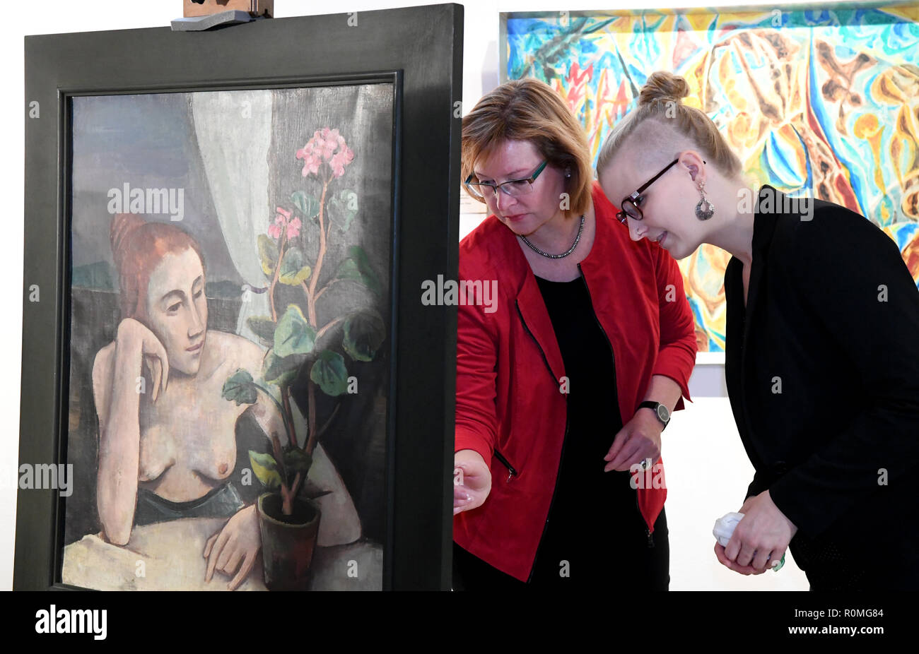 Schleswig, Germany. 06th Nov, 2018. Melanie Jacobi (r), provenance researcher of the Museum für Kunst und Kulturgeschichte, stands together with Kirsten Baumann, director of the Landesmuseum für Kunst und Kulturgeschichte, next to the painting 'Girl with Geranium' by Karl Hofer (1878-1955). For more than five years, the Schleswig-Holstein State Museums Foundation has been systematically examining and processing the collections of the Museum of Art and Cultural History. It is supported by the German Centre for the Loss of Cultural Assets in Magdeburg. Credit: Carsten Rehder/dpa/Alamy Live News Stock Photo