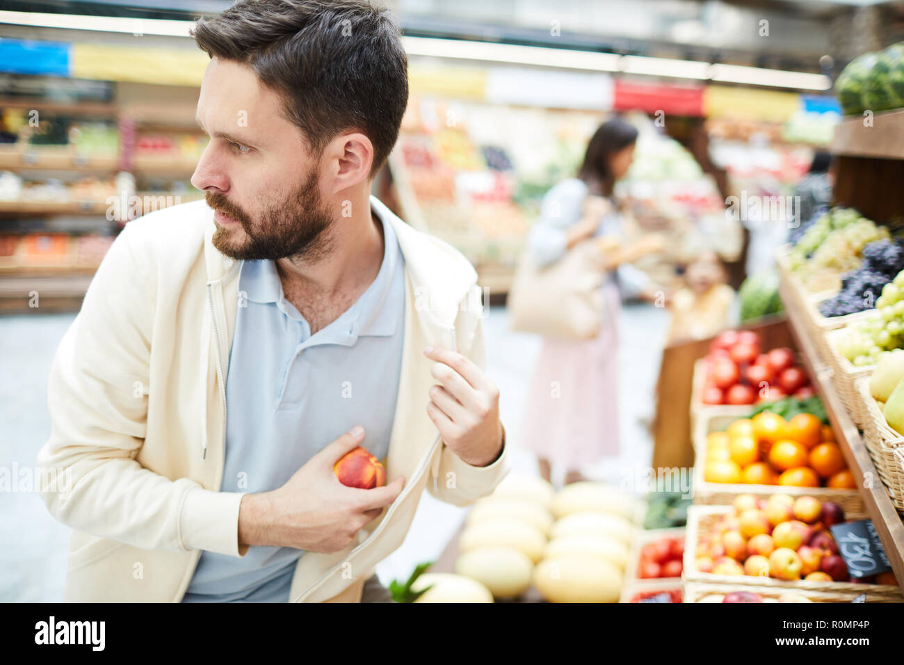 Serious worried handsome young male thief in casual clothing looking