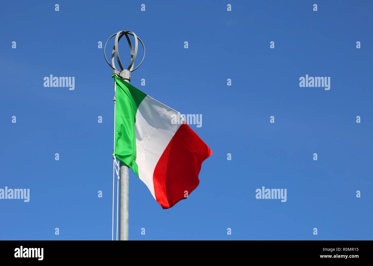 Big Italian flag waves on the blue sky Stock Photo