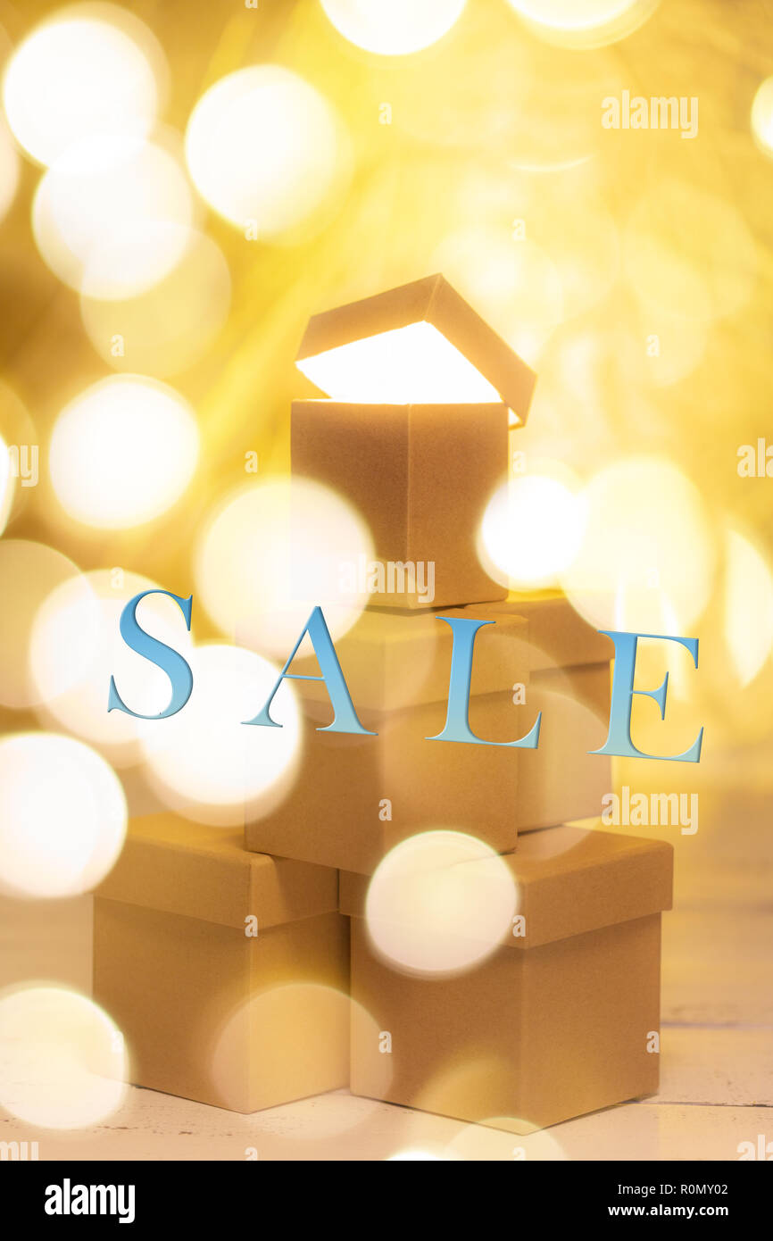 Small cardboard gift boxes with bokeh effect as concept of christmas sale. Stock Photo