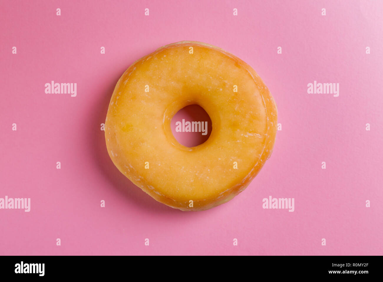 Single round donut on pink background. Stock Photo