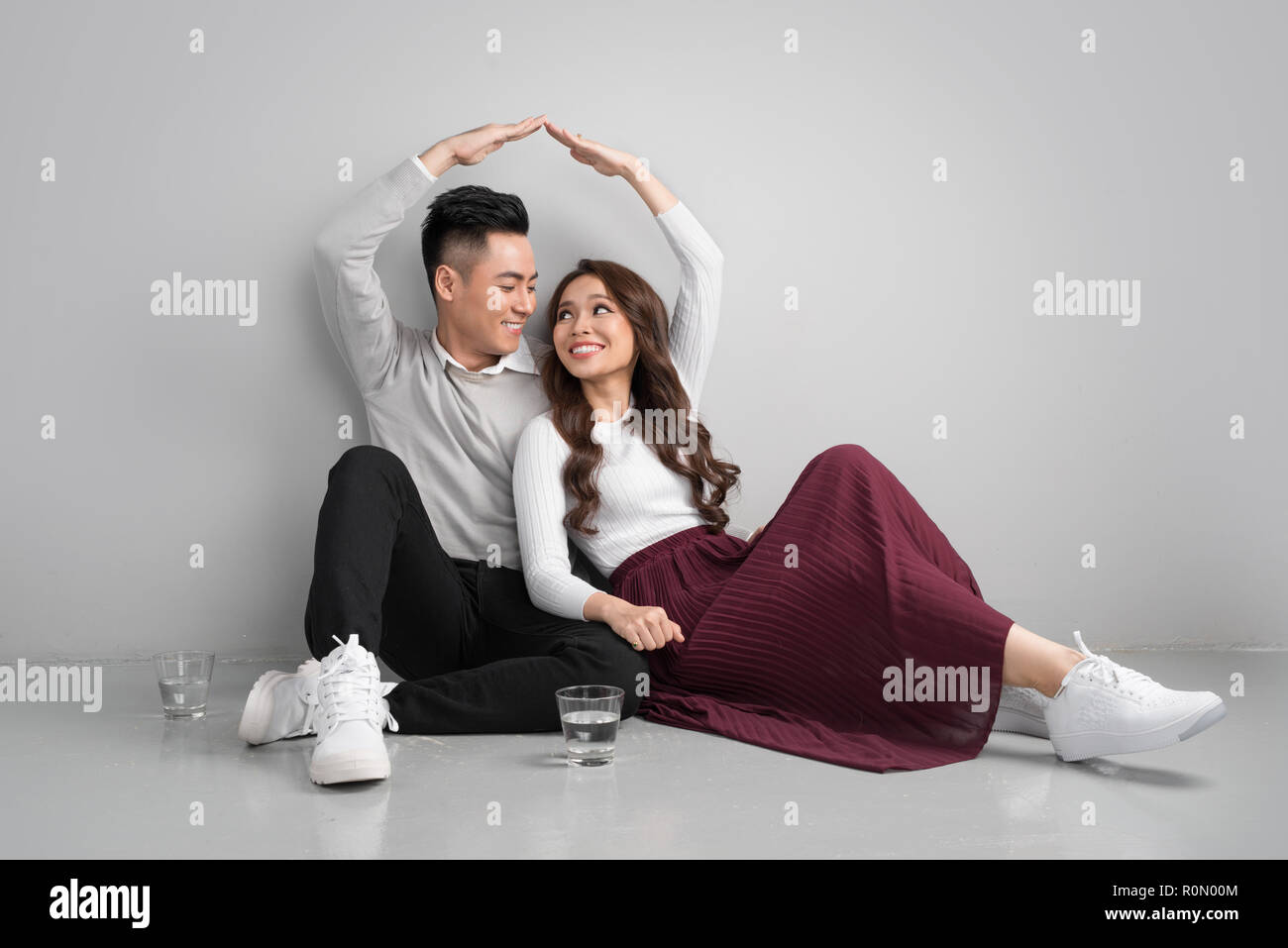 Young asian adult couple sitting on flor planning new home design. Stock Photo