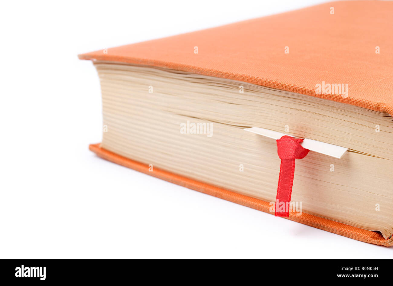 Close-up of a book with bookmark, on white background. Selective focus and shallow depth of field. Stock Photo