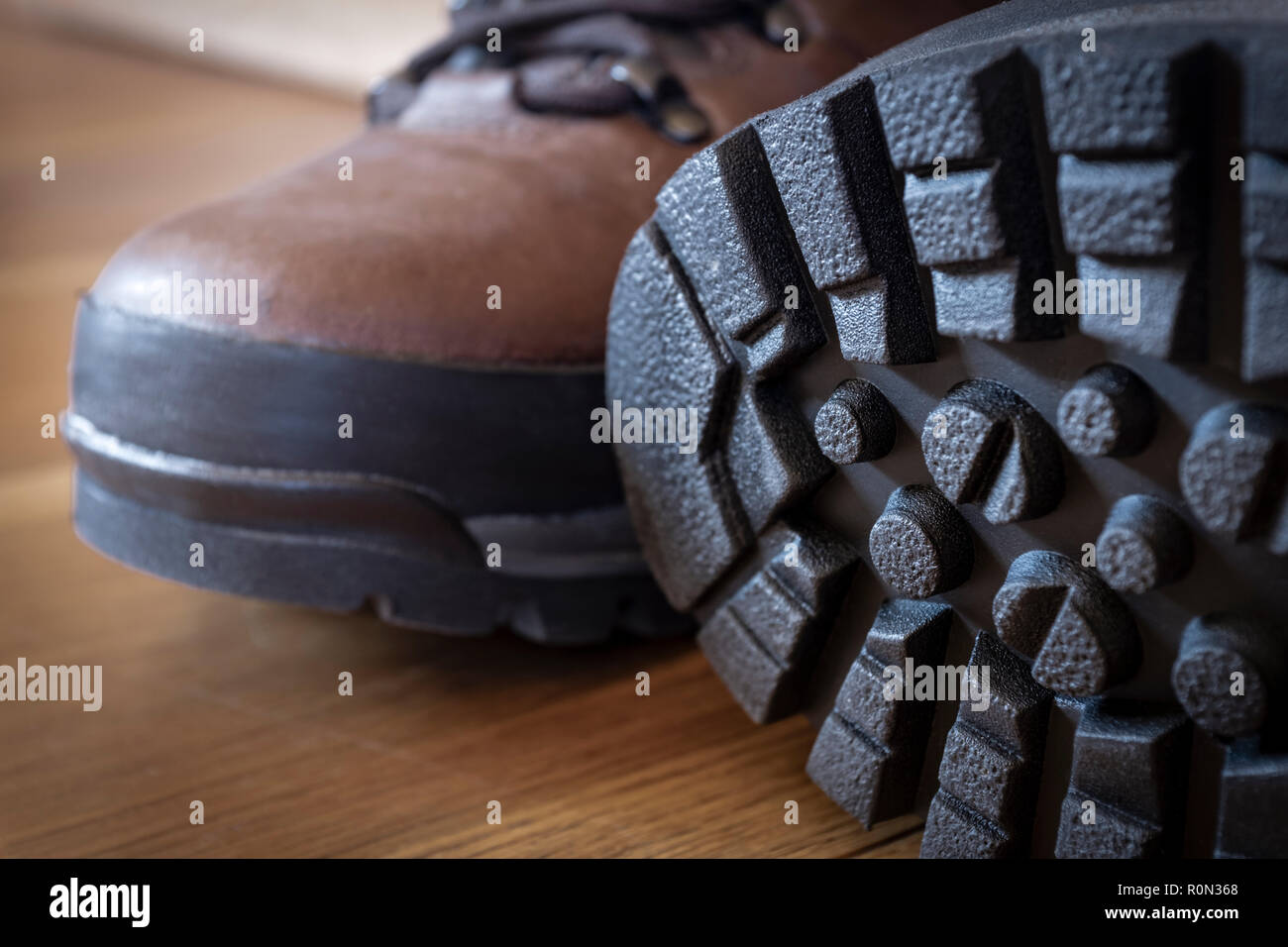 Deep tread lugs on the soles of a new pair of walking boots Stock Photo