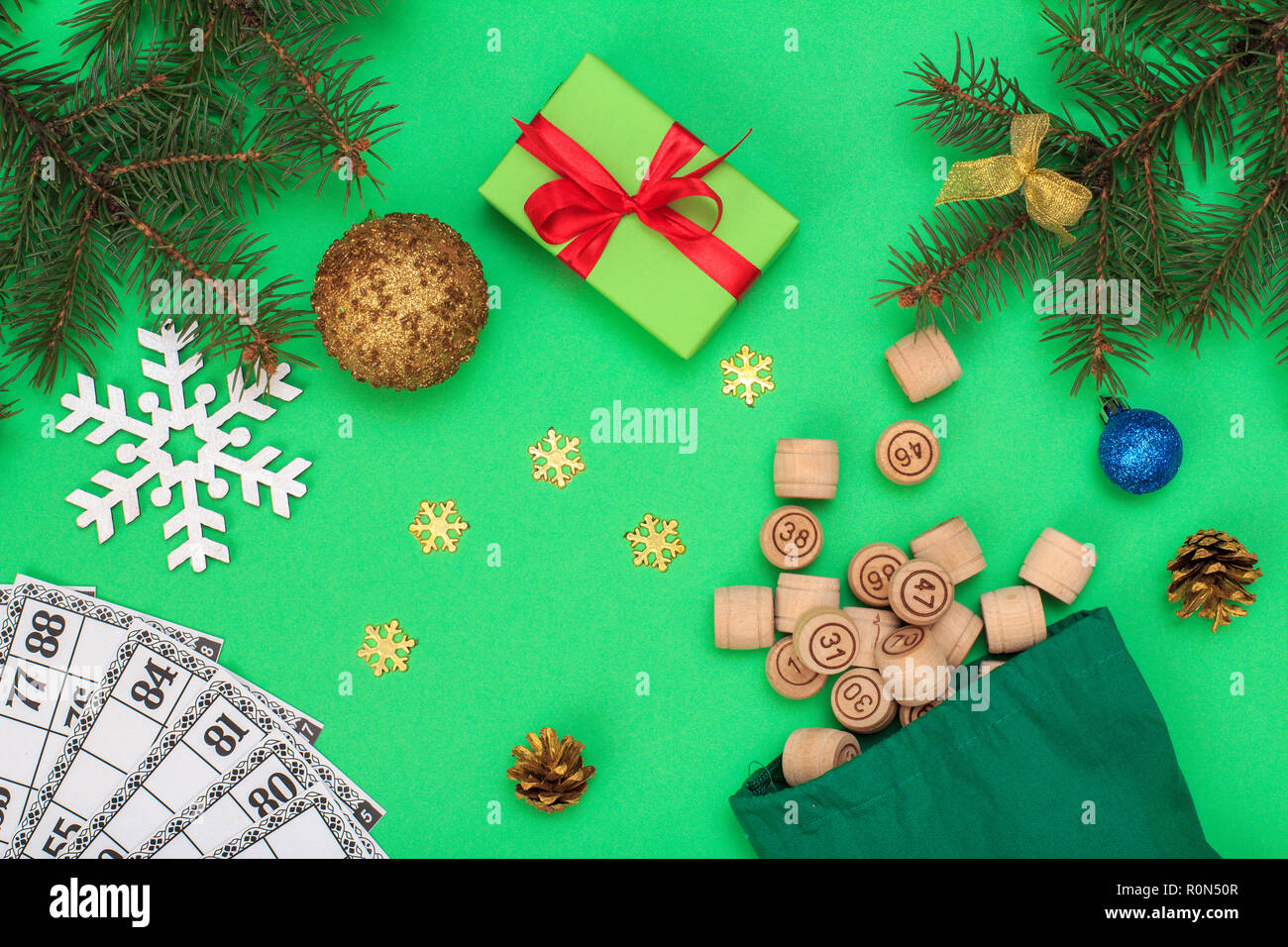 Board game lotto. Wooden lotto barrels with bag and game cards for a game in lotto, Christmas fir tree branches, cones, toy balls, snowflackes and gif Stock Photo
