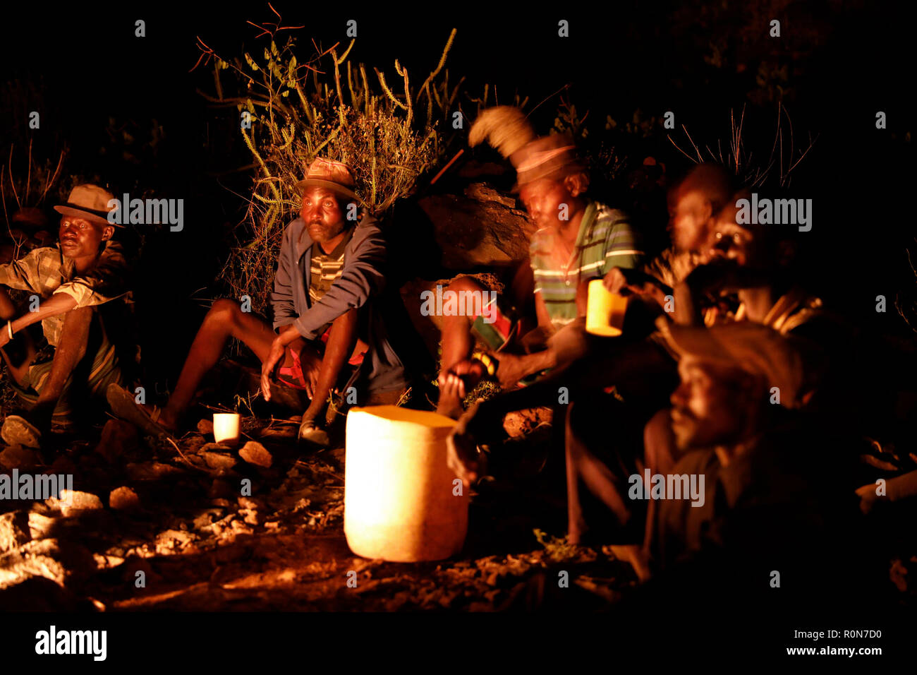 Men socialise by a fire as they drink a homemade brew in a Pokot community of herdsmen in Baringo County, Kenya, October 1, 2018. Stock Photo