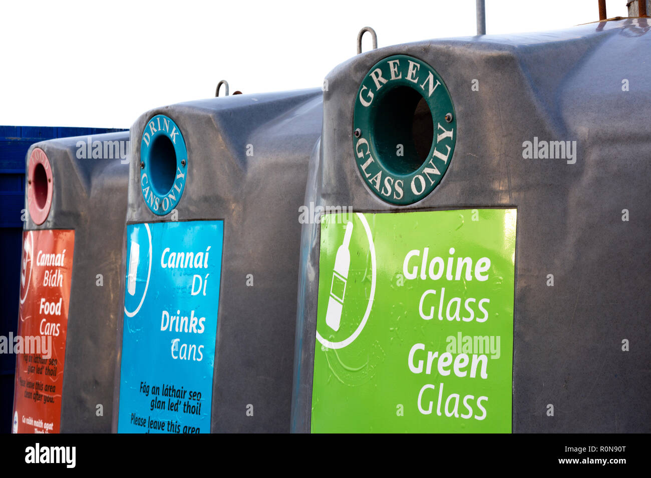 Glass recycling bins for various colours with Irish writing Stock Photo