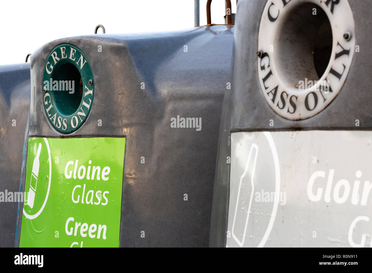 Glass recycling bins for various colours with Irish writing Stock Photo Alamy