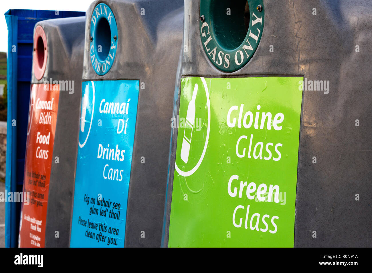 Glass recycling bins for various colours with Irish writing Stock Photo