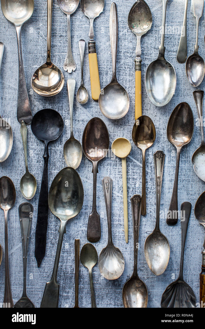 Many vintage spoons as a pattern on a textured gray board Stock Photo
