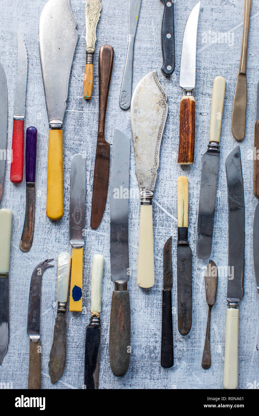 Many vintage knives as a pattern on a textured gray board Stock Photo