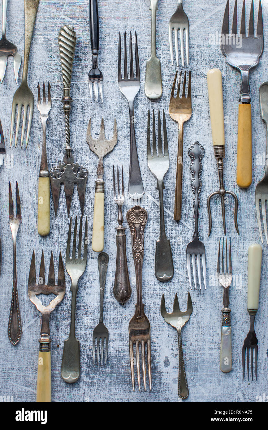 Many vintage forks as a pattern on a textured gray board. Stock Photo