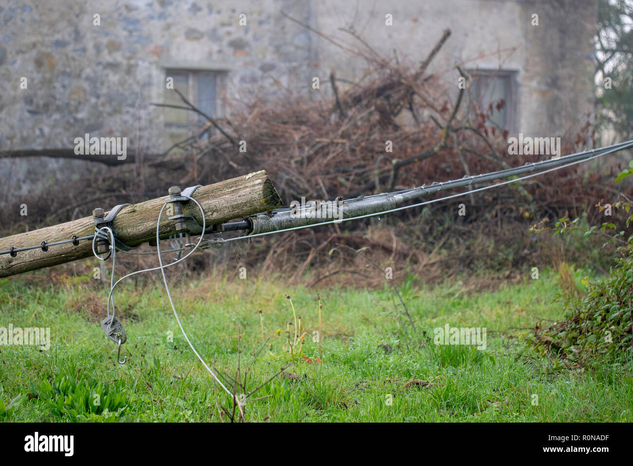 Phone lines down following storms and strong winds resulting in fallen wooden telegraph pole. Rural Italy. Stock Photo