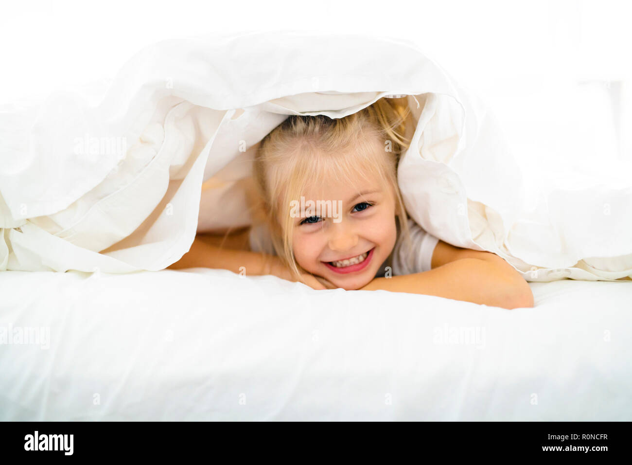 A Cheerful little girl in bed having fun Stock Photo Alamy