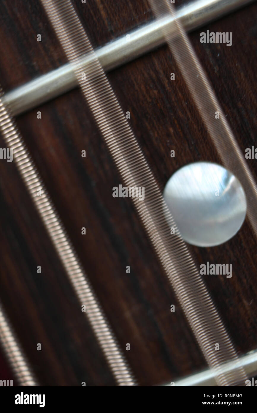 Acoustic guitar fretboard with steel strings vibrating, closeup Stock