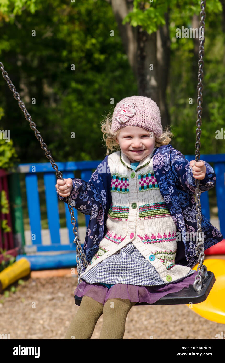 happy blond girl on a swing Stock Photo