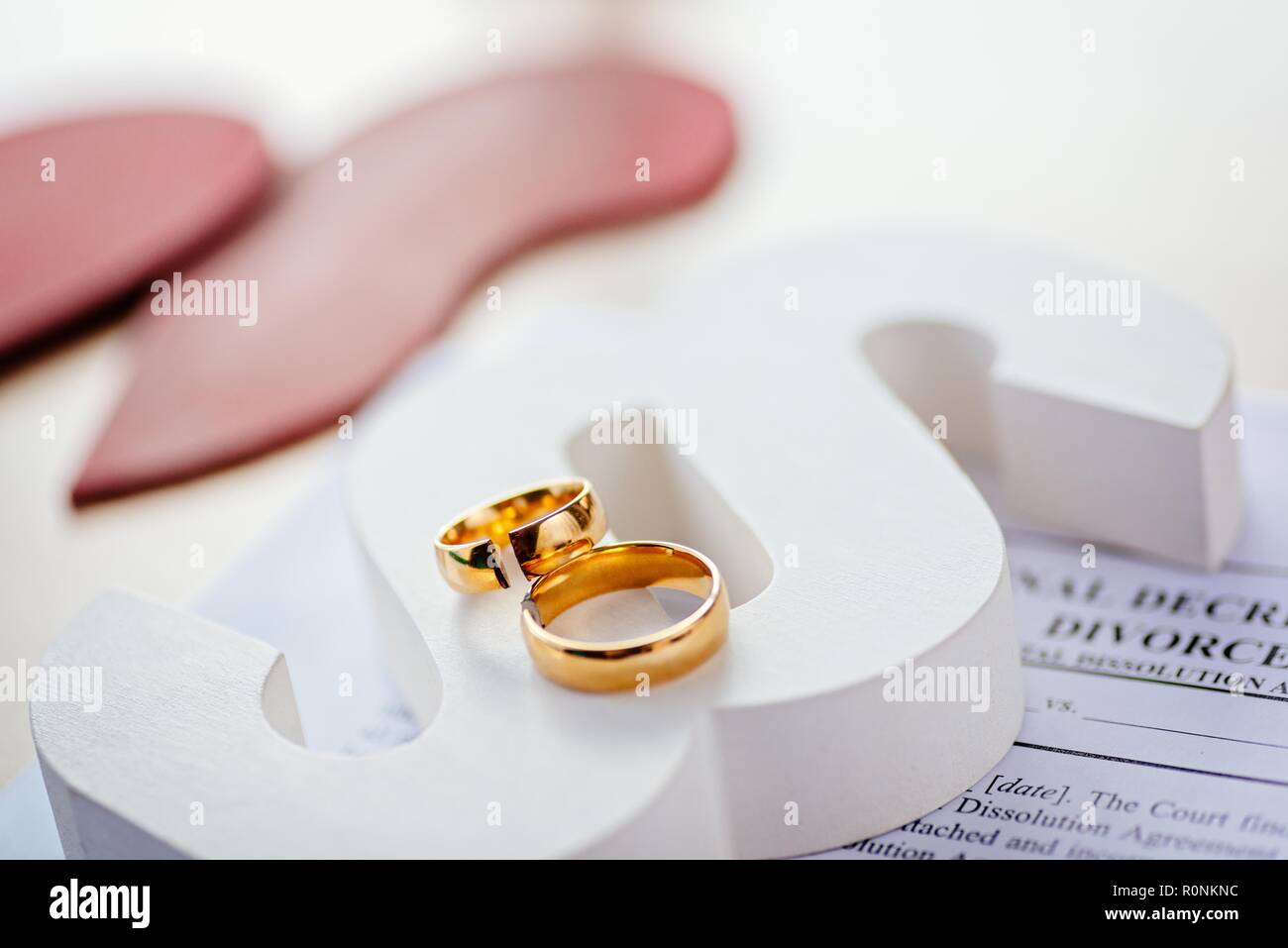Two broken wedding rings on wooden paragraph. Divorce, separation and