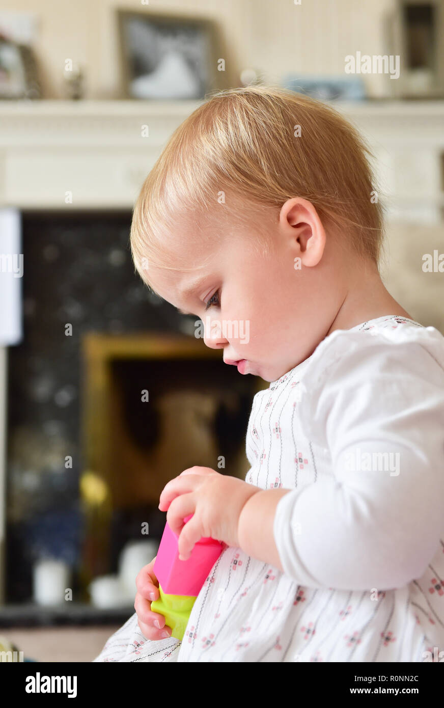 Young baby toddler girl aged two years old playing alone Photograph