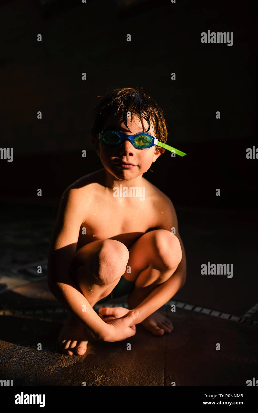 Portrait of a boy wearing swimming trunks and swimming goggles Stock Photo