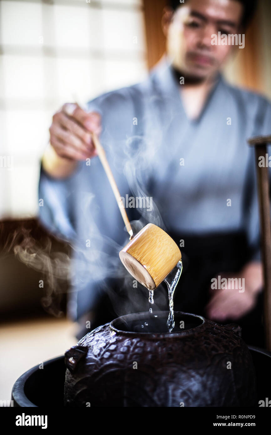 Close up of traditional Japanese Tea Ceremony, man using a Hishaku, a