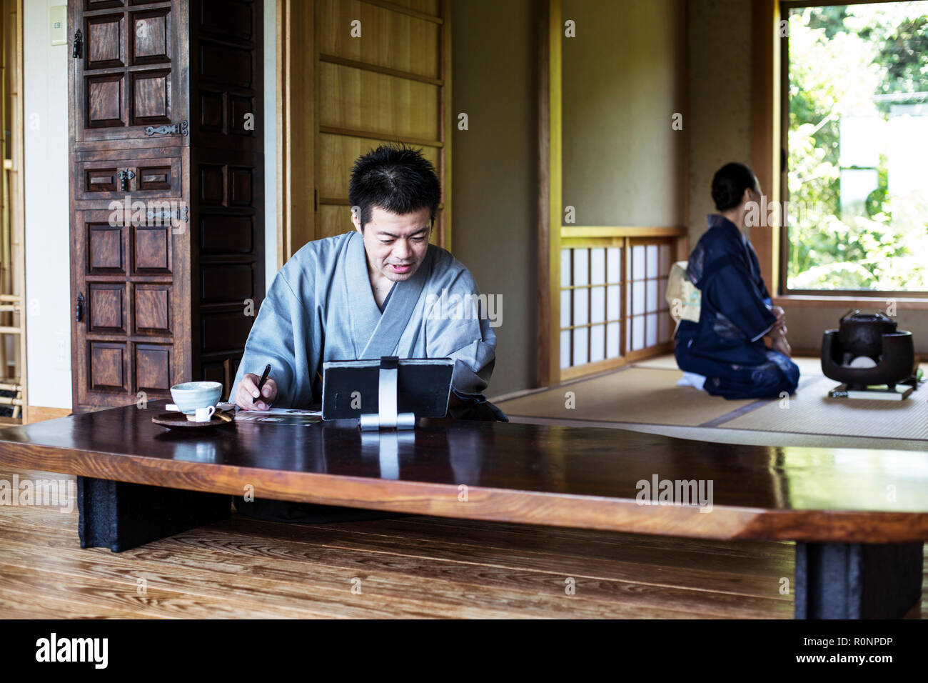 Japanese Man Wearing Kimono Sitting On Floor In Traditional