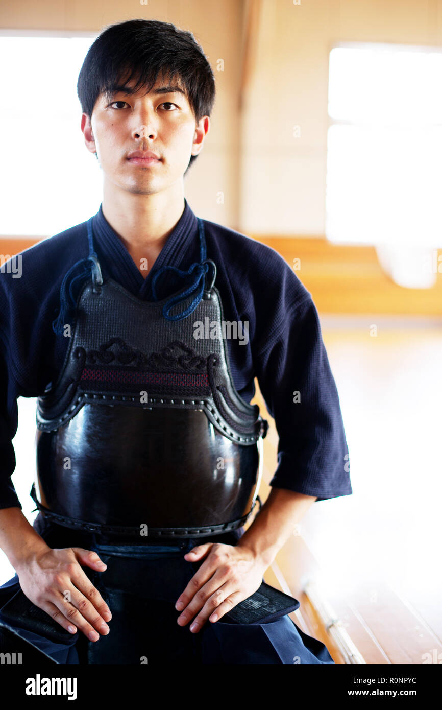 Male Japanese Kendo fighter kneeling on floor, looking at camera. Stock Photo