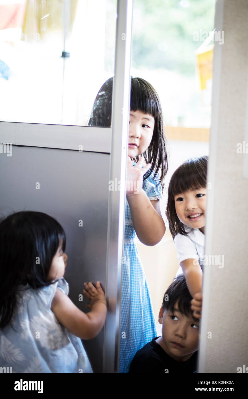 Group of girls playing hide and seek in a Japanese preschool. Stock Photo