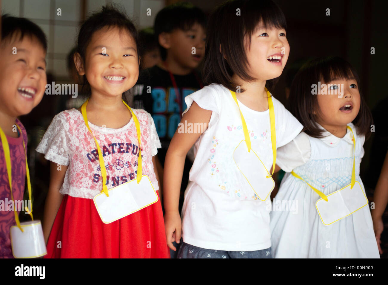 Group of girls and boys wearing name tags singing together in a temple. Stock Photo