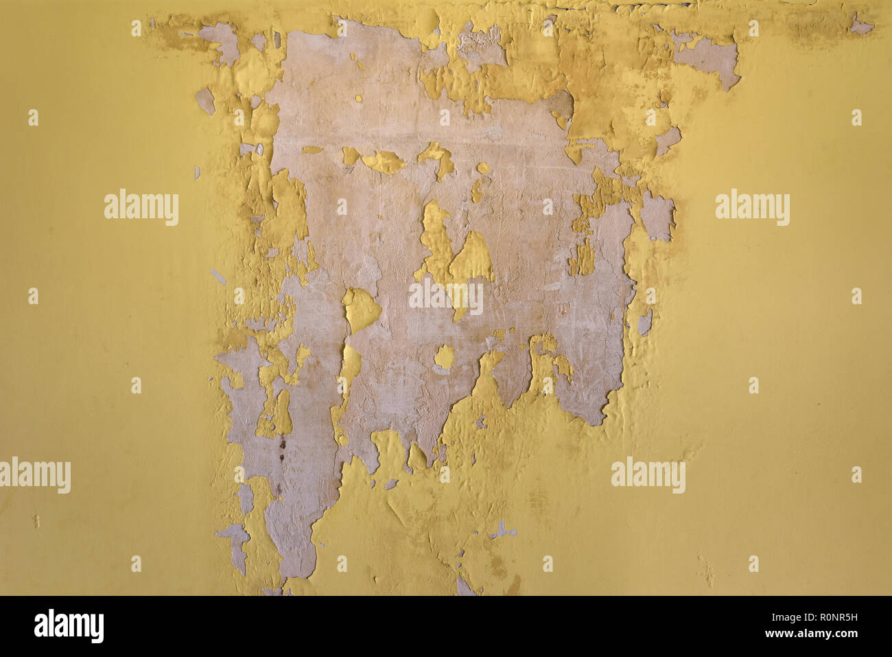 Old cracked yellow plaster on the wall. Grunge texture background. Stock Photo