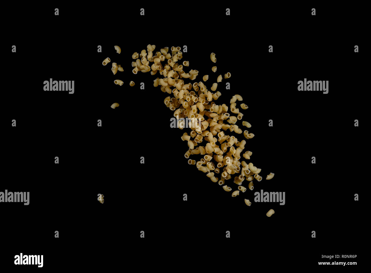 Flying pasta isolated on black background. Abstract macaroni falling. Stock Photo