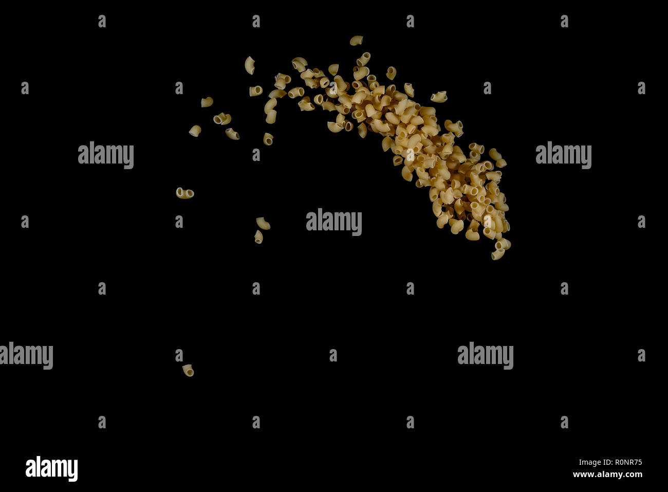 Flying pasta isolated on black background. Abstract macaroni falling. Stock Photo