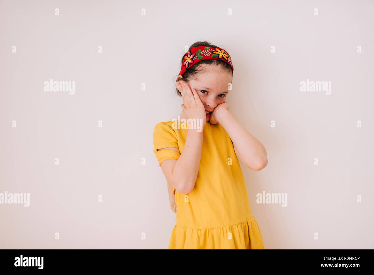 Portrait of a smiling girl with hands on her face Stock Photo - Alamy