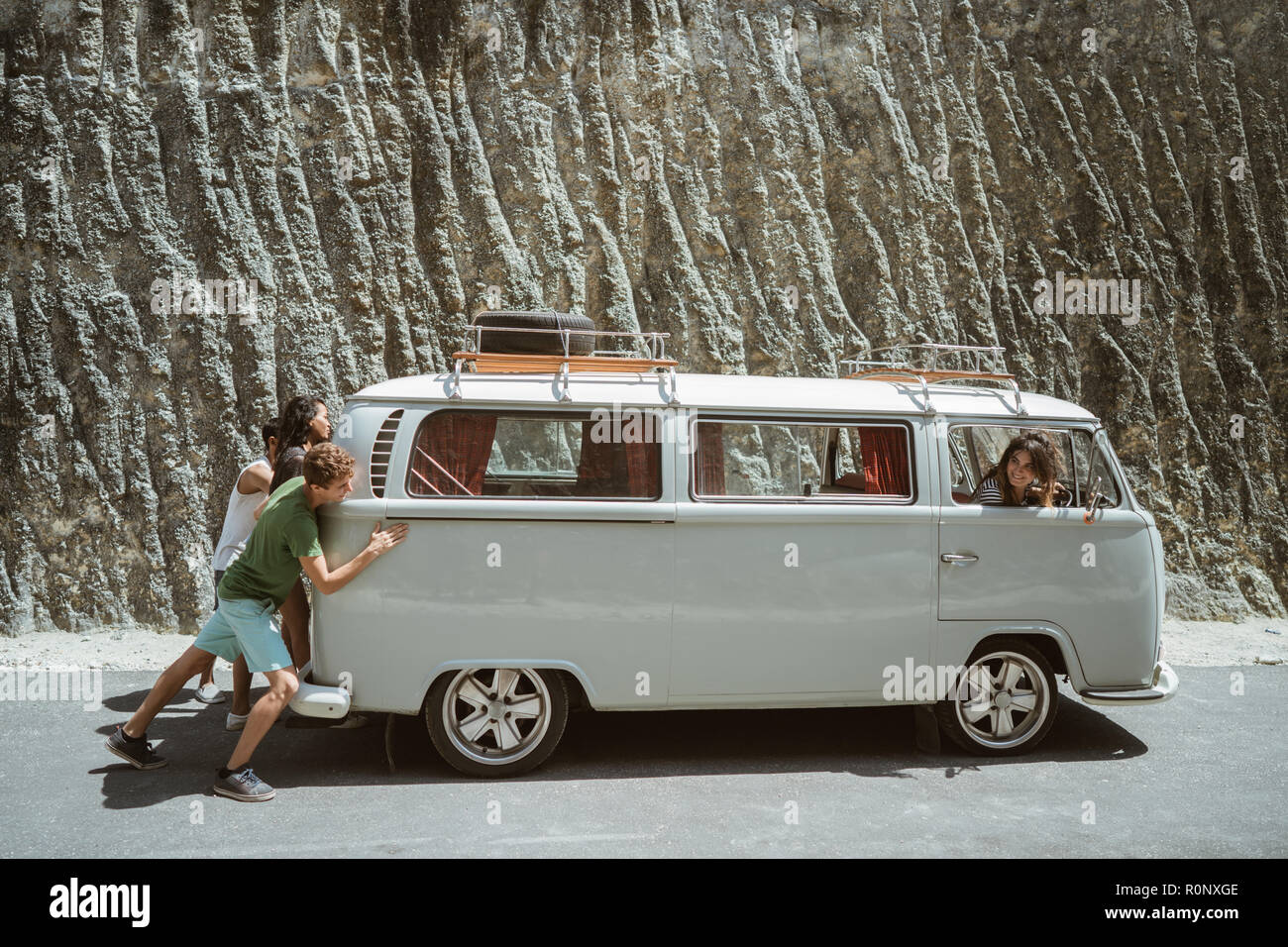 young people push broke down retro van Stock Photo