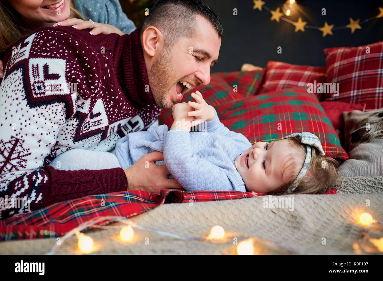 The family with child plays indoors on Christmas Day. Stock Photo