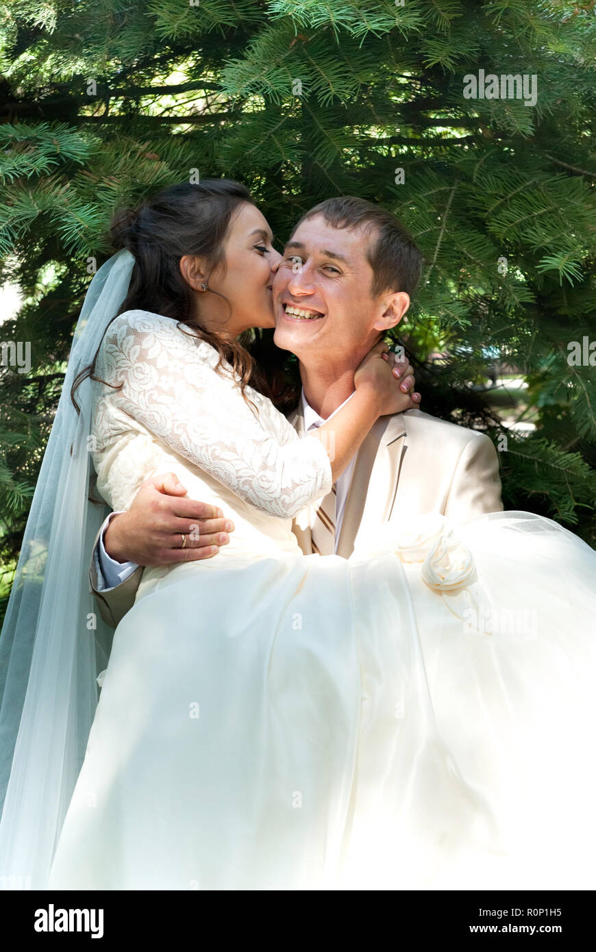 bride kissing groom in the park Stock Photo - Alamy