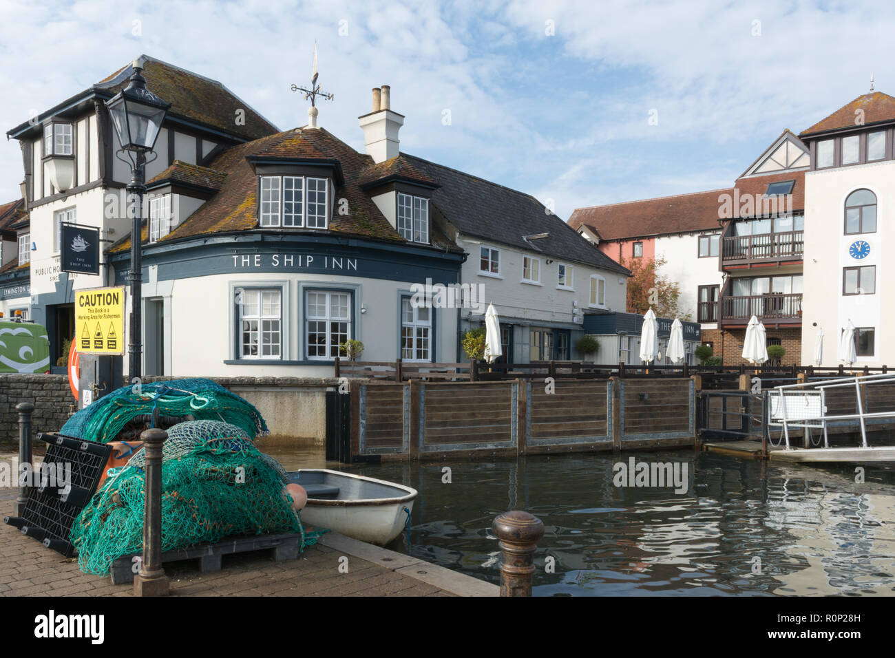 The Ship Inn beside Lymington Harbour, Lymington, Hampshire, UK, with fishing nets and a boat Stock Photo