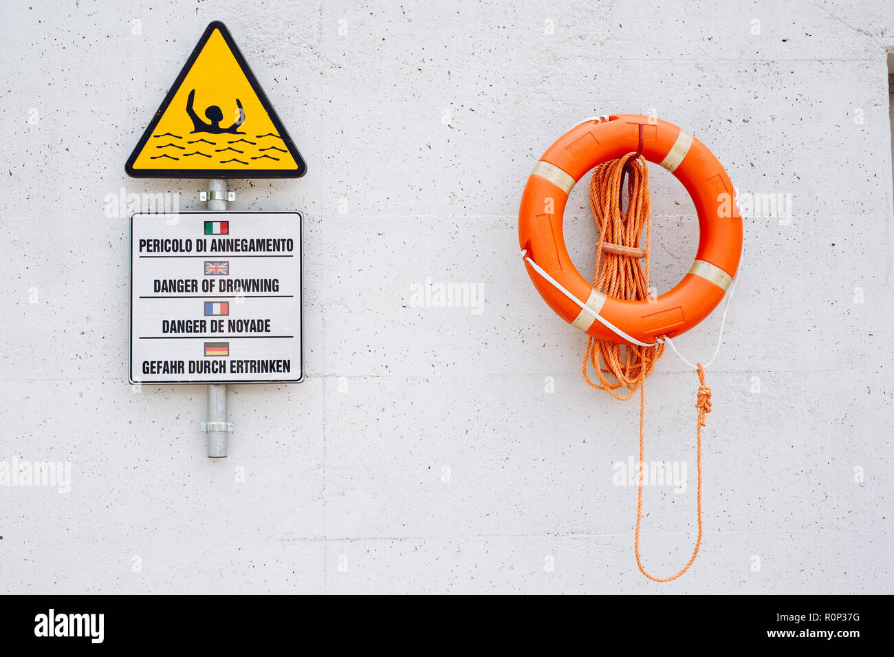 flood warning sign and life buoy with rope, hanging on the wall of a ...