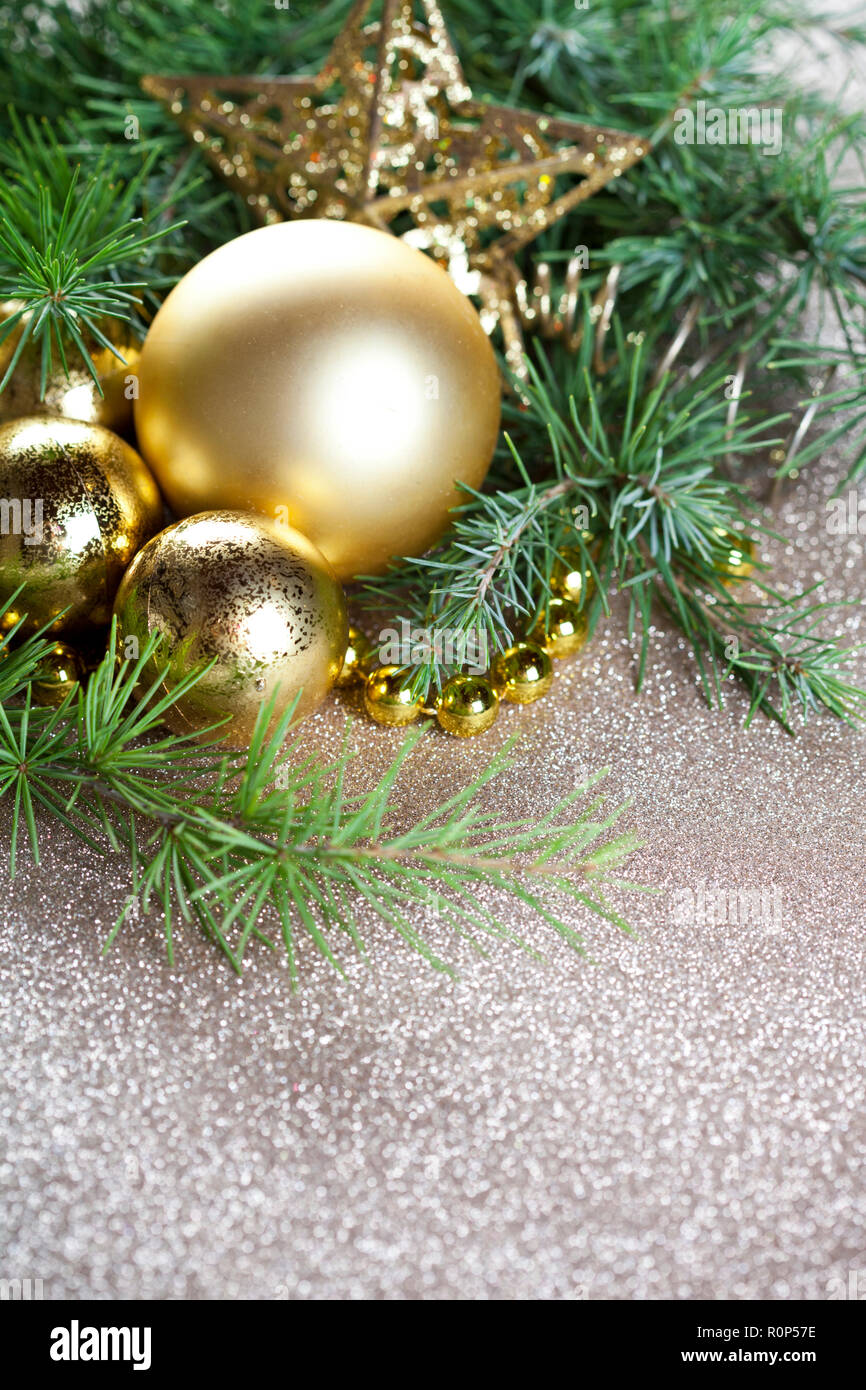 Christmas decorations and evergreen fir tree branch closeup on gold ...