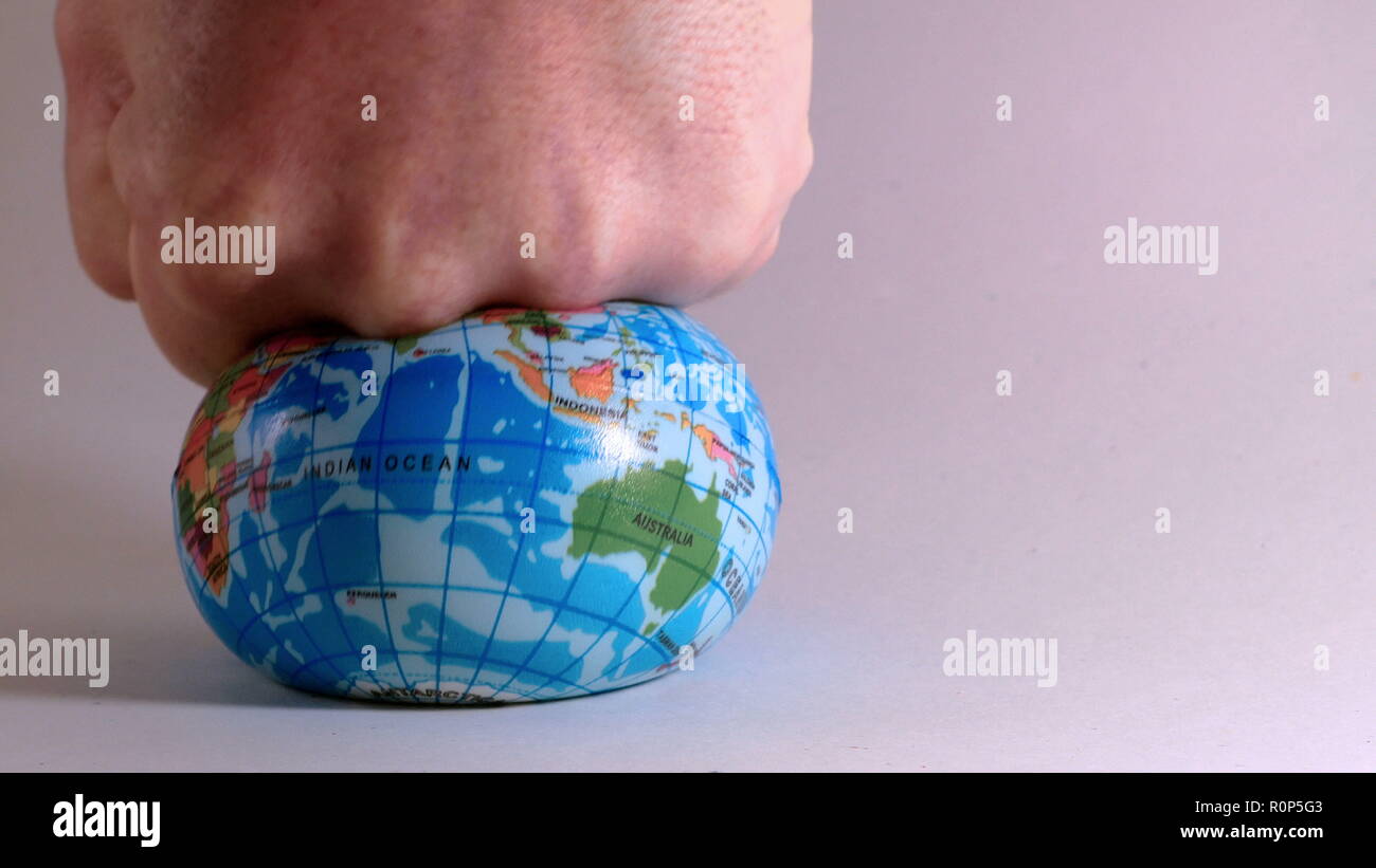world globe is crushed by a man's fist, ecological problems Stock Photo