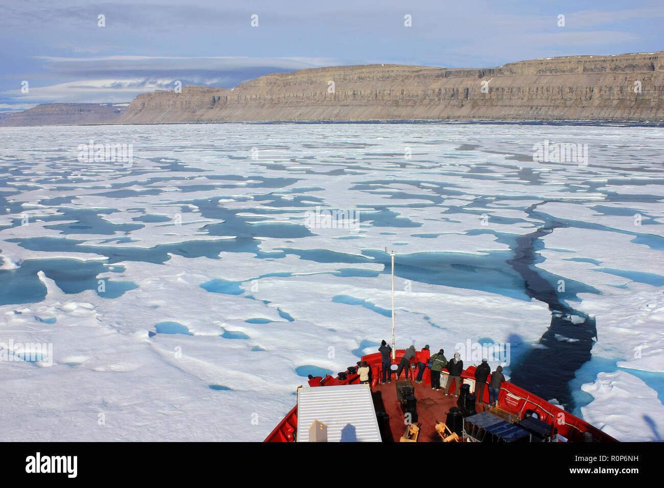 Scientists at the prow of the CCGS Amundsen as she breaks through the ice in Lancaster Sound, Arctic Canada Stock Photo