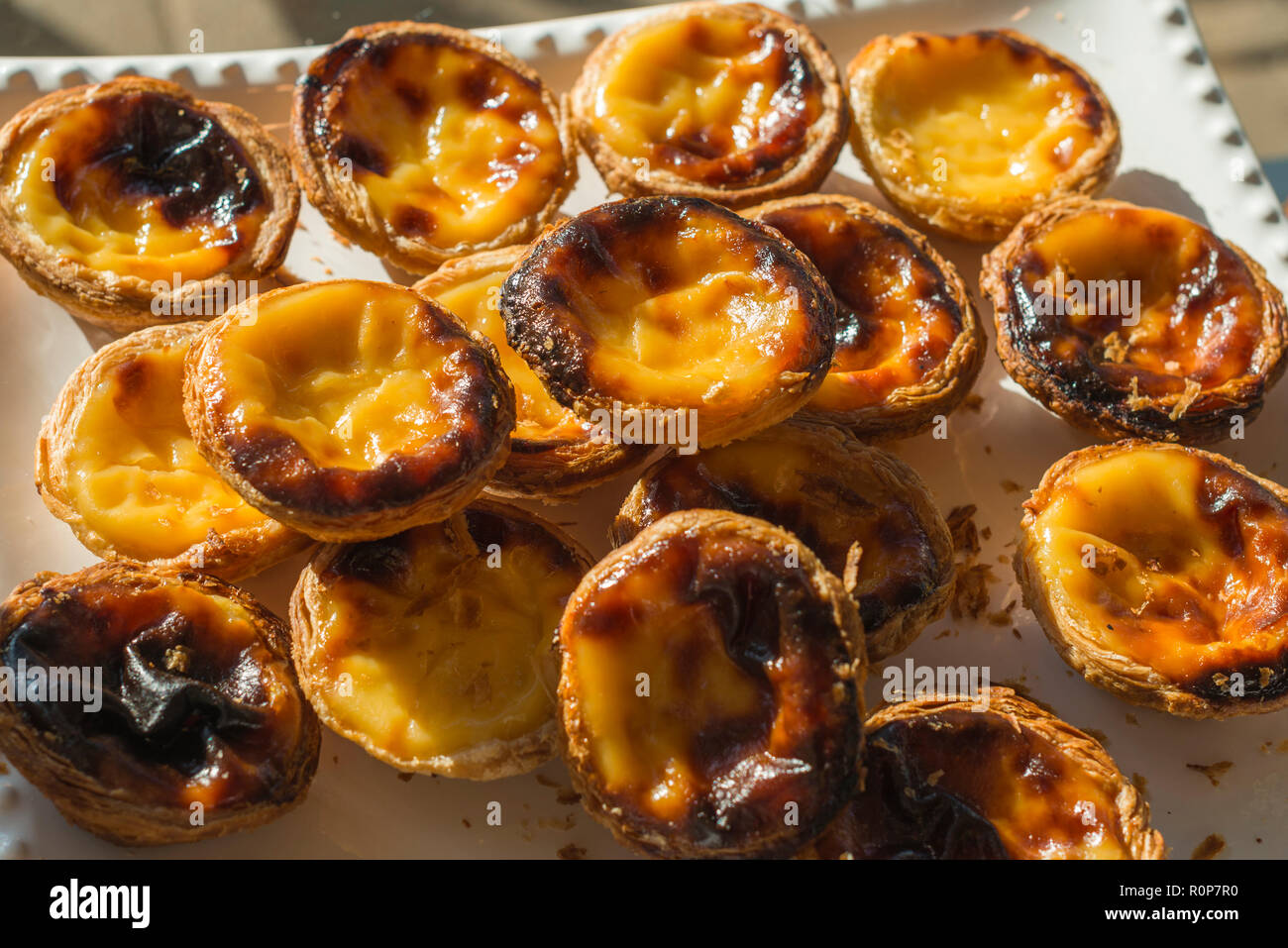 Pastel de nata is a Portuguese egg tart pastry dusted with cinnamon. Stock Photo