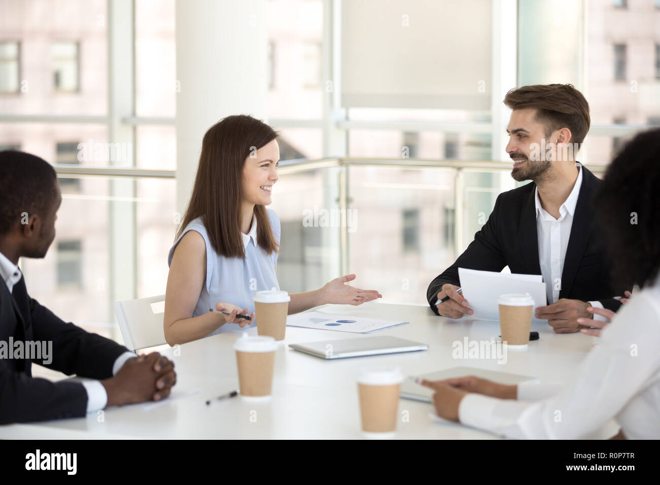 Millennial employees smiling negotiating at office briefing Stock Photo