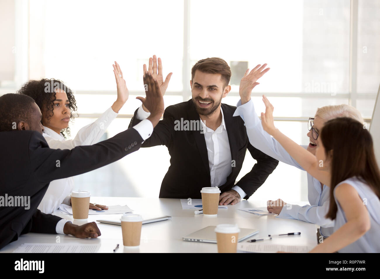 Excited diverse employees give high five celebrating success Stock ...