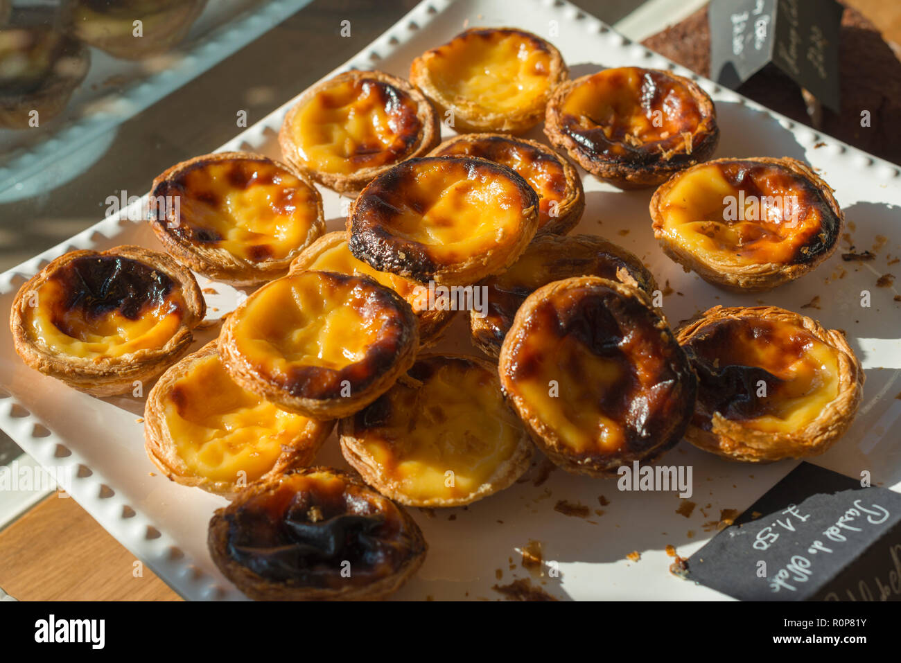 Pastel de nata is a Portuguese egg tart pastry dusted with cinnamon. Stock Photo