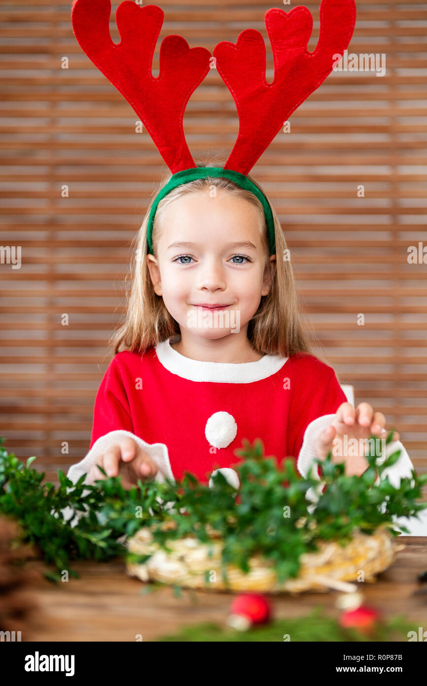 Cute preschooler girl dressed in reindeer costume wearing reindeer