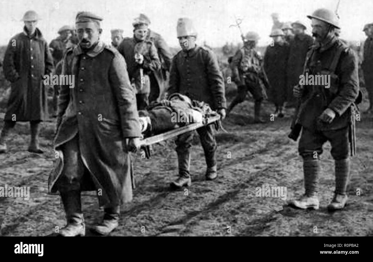 A British soldier supervising captured German prisoners of War to carry the  injured from the battlefield Stock Photo